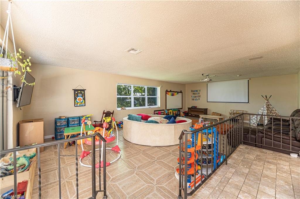 339 Delaware Road Lehigh Acres, FL 33936 - Photo 26 of 30 a living room with lots of furniture and a chandelier