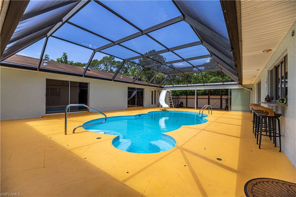 339 Delaware Road Lehigh Acres, FL 33936 - Photo 4 of 30 a view of a swimming pool with a lounge chairs