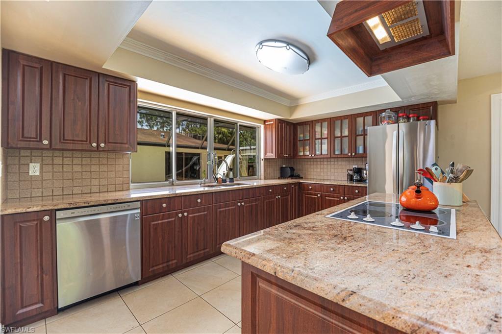 339 Delaware Road Lehigh Acres, FL 33936 - Photo 7 of 30 a kitchen with stainless steel appliances granite countertop a sink dishwasher and cabinets with wooden floor