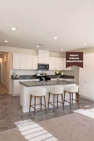 a kitchen with stainless steel appliances granite countertop a table chairs sink and cabinets