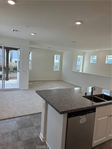 a kitchen with a sink a counter space and wooden floor