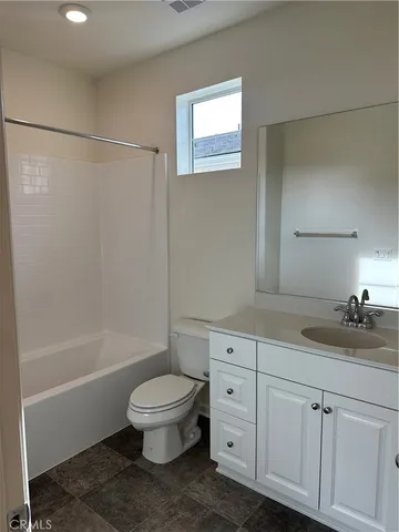 a bathroom with a granite countertop sink a toilet and shower