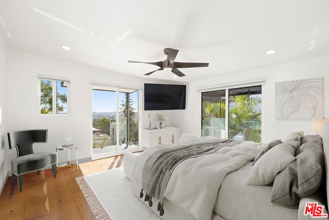 1788 North Orange Grove Avenue Los Angeles, CA 90046 - Photo 6 of 20 a bed sitting in a bedroom next to a large window with a flat screen tv