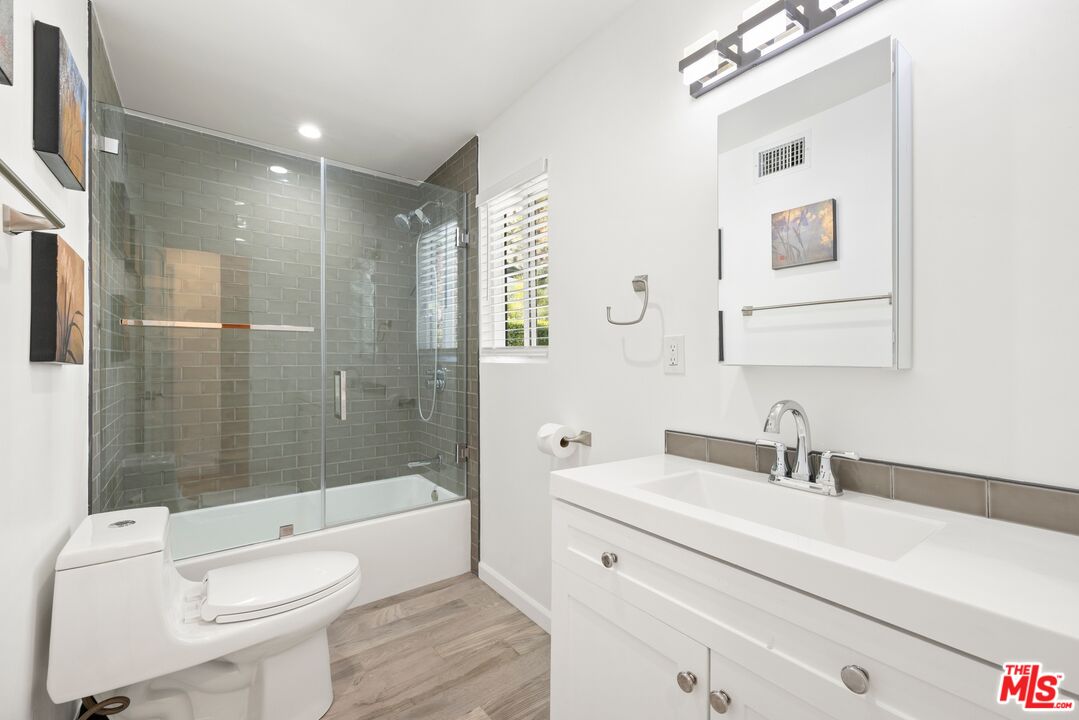 1788 North Orange Grove Avenue Los Angeles, CA 90046 - Photo 10 of 20 a bathroom with a toilet a sink a mirror a bathtub and shower