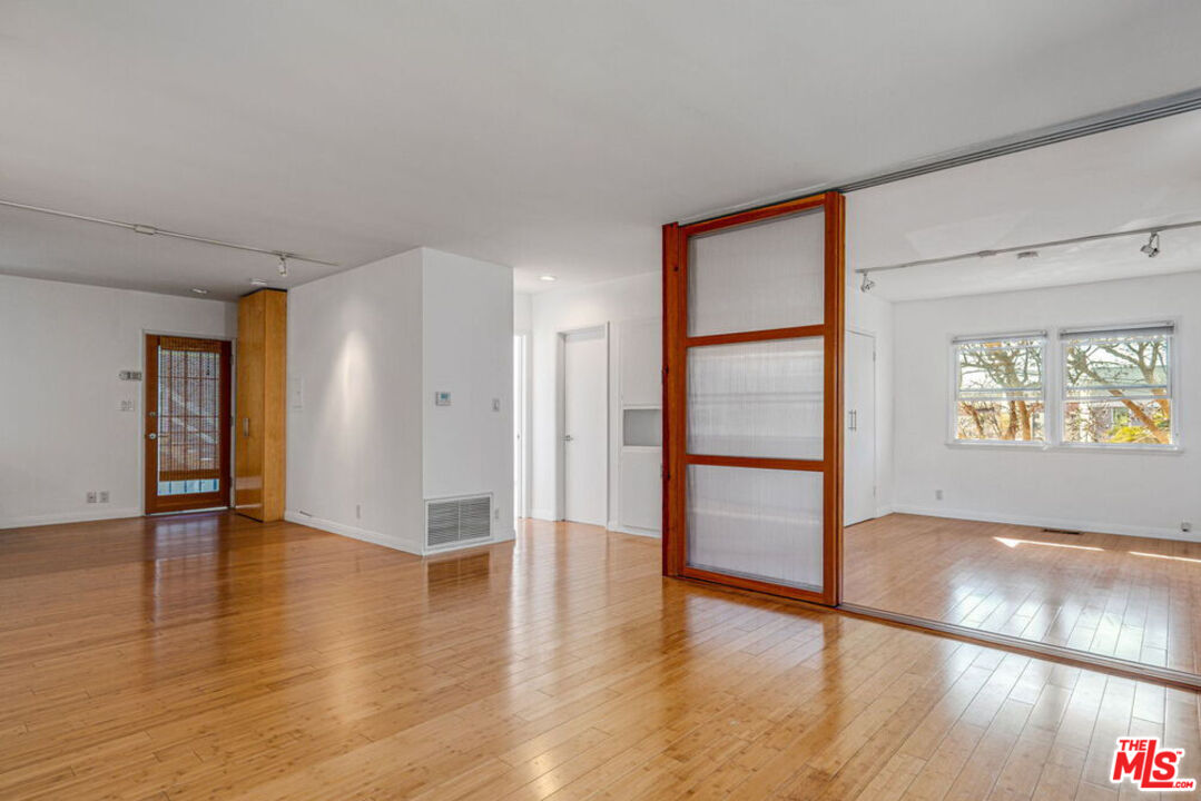 219 3rd Avenue, Unit 1/2 Venice, CA 90291 - Photo 3 of 13 an empty room with wooden floor and windows