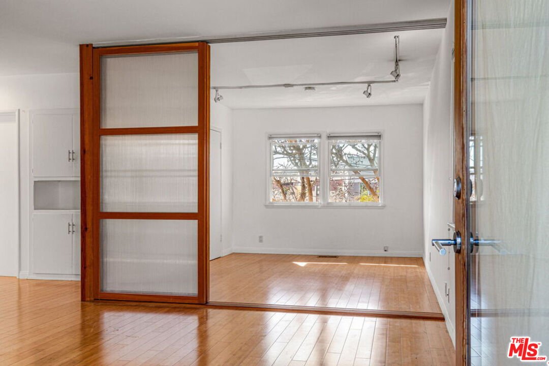 219 3rd Avenue, Unit 1/2 Venice, CA 90291 - Photo 5 of 13 a view of an empty room with wooden floor and a window