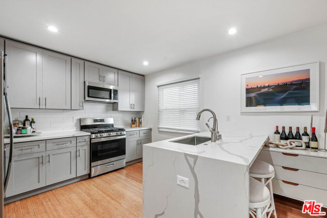 219 3rd Avenue, Unit 1/2 Venice, CA 90291 - Photo 6 of 13 a kitchen with stainless steel appliances granite countertop a sink and cabinets