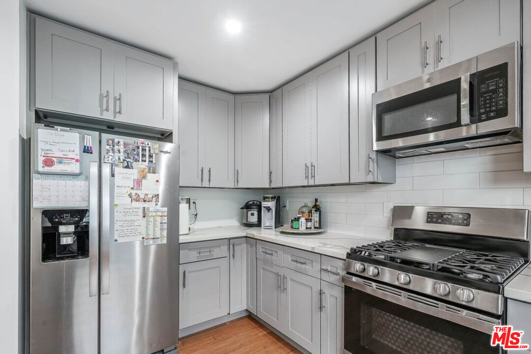 219 3rd Avenue, Unit 1/2 Venice, CA 90291 - Photo 7 of 13 a kitchen with stainless steel appliances granite countertop a refrigerator stove and white cabinets