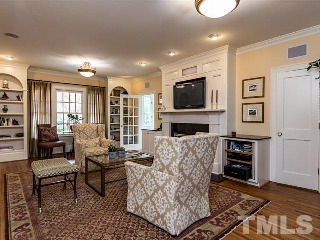 807 Harvey Street Raleigh, NC 27608 - Photo 5 of 24 a living room with furniture a flat screen tv and a fireplace