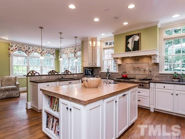 807 Harvey Street Raleigh, NC 27608 - Photo 8 of 24 a kitchen with stainless steel appliances granite countertop a sink a stove and a wooden floors