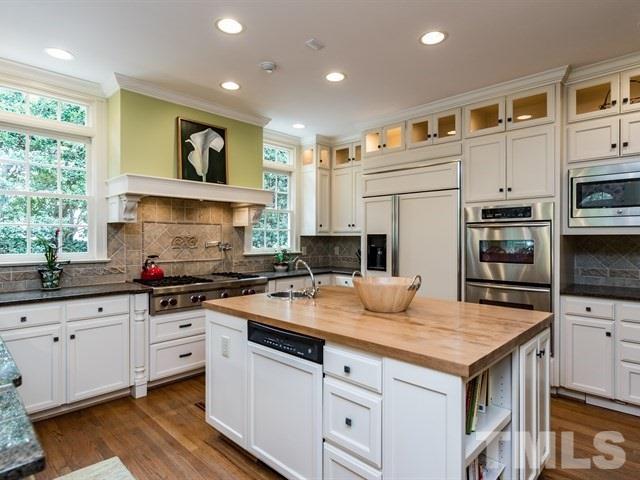 807 Harvey Street Raleigh, NC 27608 - Photo 9 of 24 a kitchen with stainless steel appliances a sink stove and cabinets