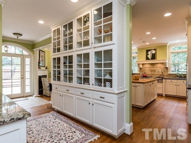807 Harvey Street Raleigh, NC 27608 - Photo 10 of 24 a kitchen with a refrigerator and white cabinets