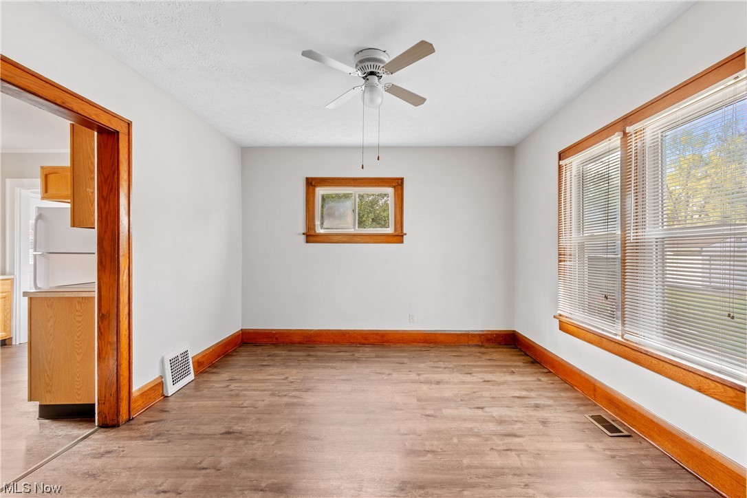 1529 Walnut Road Southwest Massillon, OH 44647 - Photo 6 of 27 Empty room featuring a healthy amount of sunlight, light hardwood floors, and ceiling fan