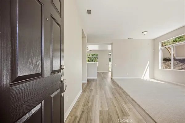 a view of a hallway with wooden floor and staircase