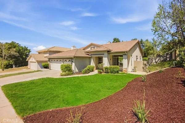 a front view of a house with a garden and yard