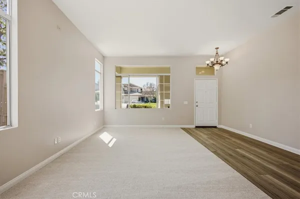 an empty room with windows and mirror