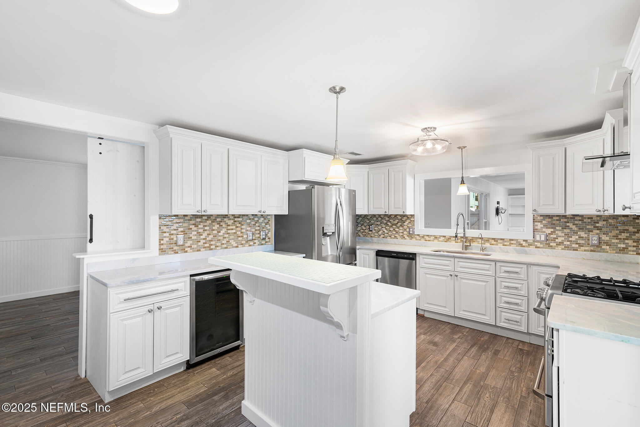 370 10th Street Atlantic Beach, FL 32233 - Photo 12 of 24 a kitchen with a sink stove a refrigerator and white cabinets