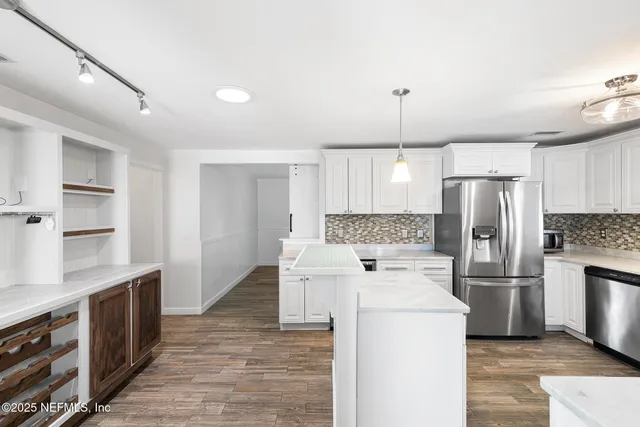 a kitchen with a refrigerator sink and cabinets