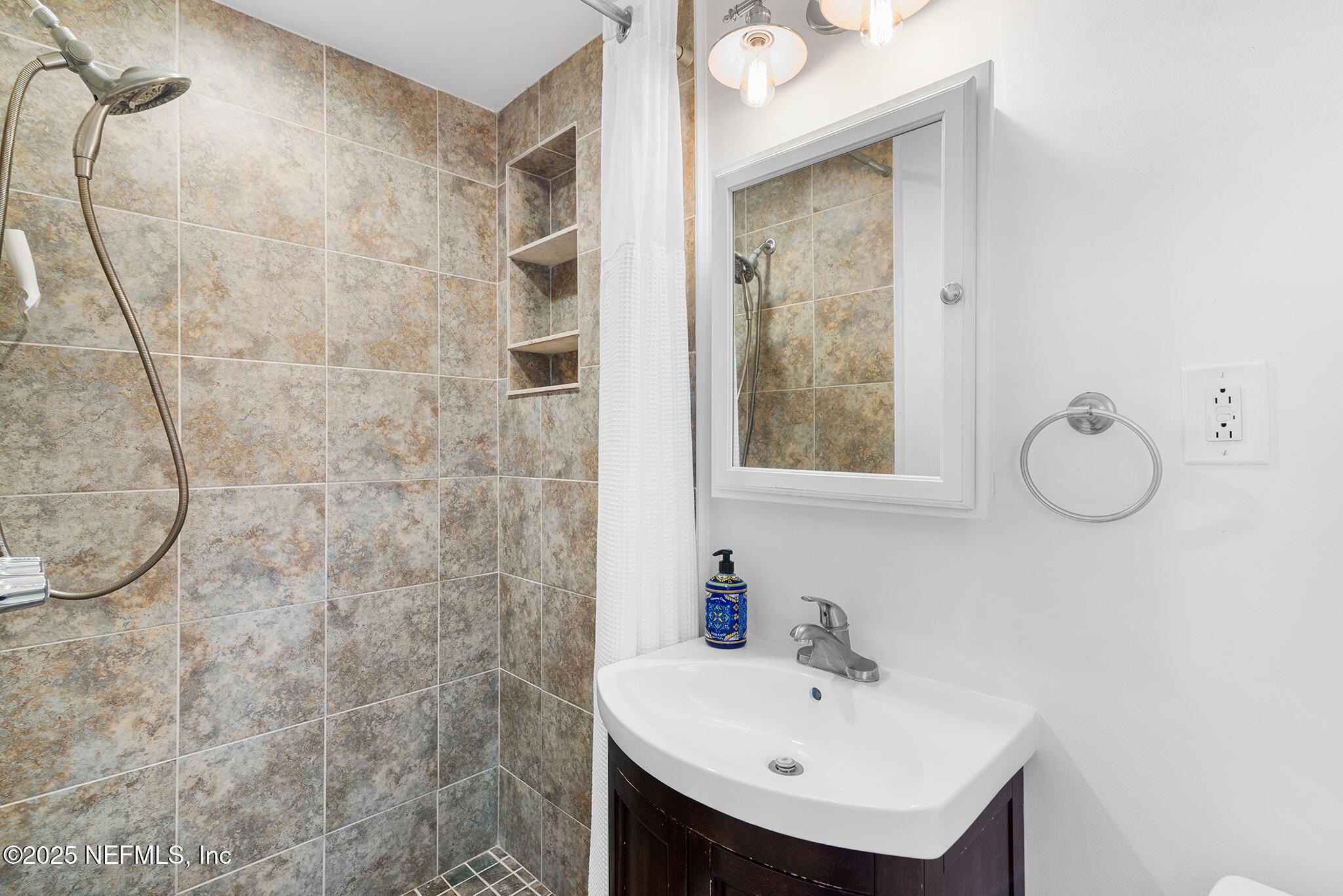 370 10th Street Atlantic Beach, FL 32233 - Photo 16 of 24 a bathroom with a sink a mirror and shower