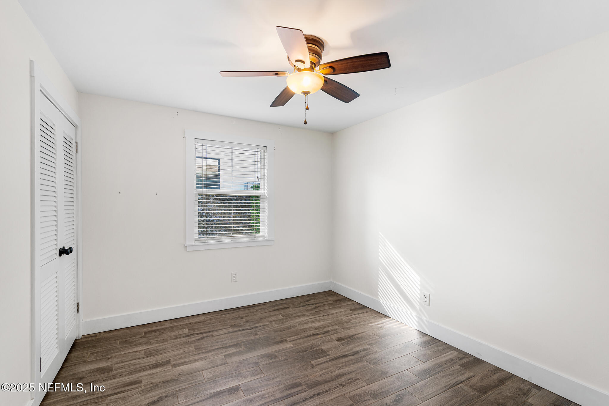 370 10th Street Atlantic Beach, FL 32233 - Photo 18 of 24 an empty room with wooden floor chandelier fan and windows