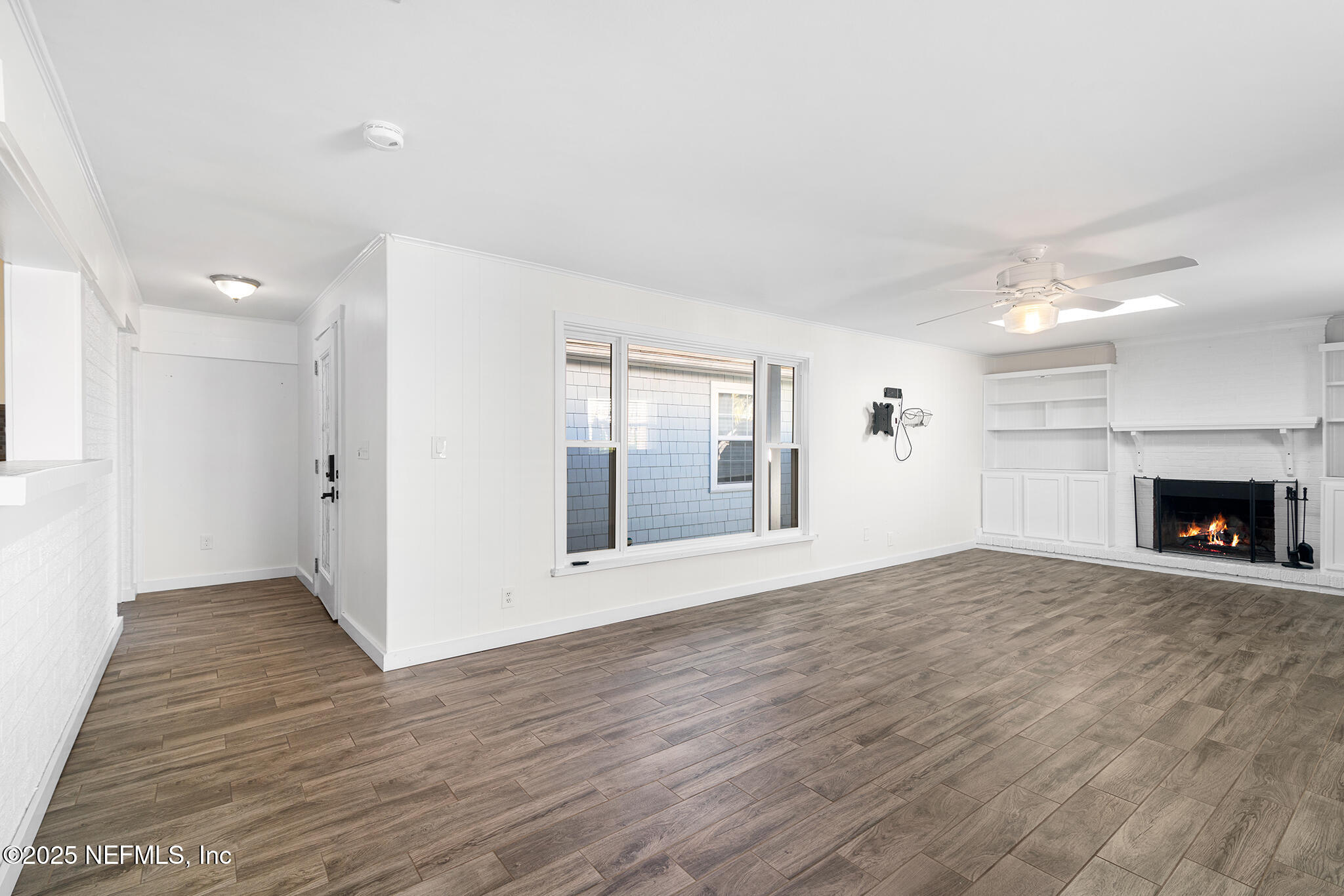 370 10th Street Atlantic Beach, FL 32233 - Photo 3 of 24 a view of an empty room with wooden floor and a fireplace