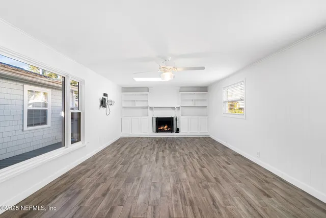 a view of an empty room with a fireplace and a window