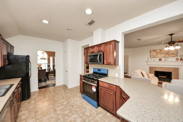 a kitchen with stainless steel appliances granite countertop a refrigerator stove oven sink and stove