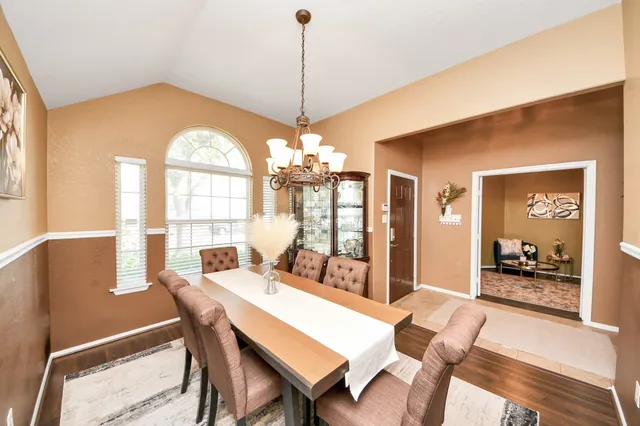 a dining room with furniture a chandelier and window