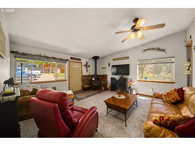 a living room with furniture ceiling fan and a window