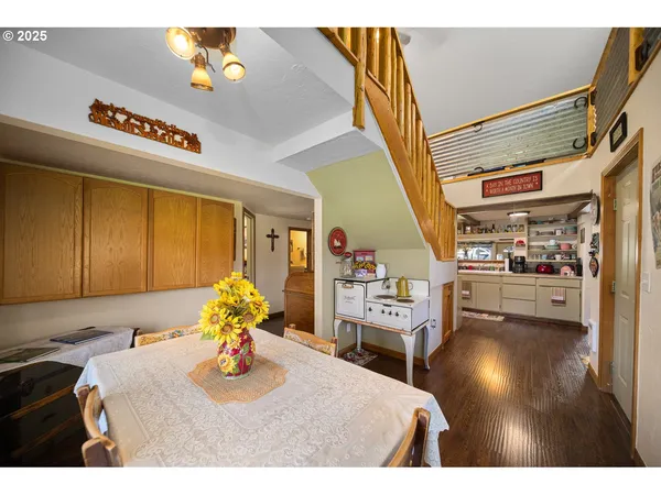 a kitchen with stainless steel appliances granite countertop a sink a stove top oven a chimney and a dining table