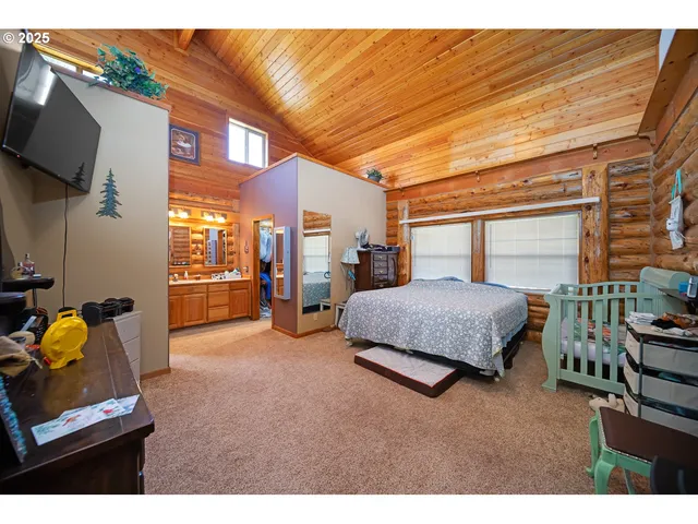 a bedroom with furniture and a flat screen tv