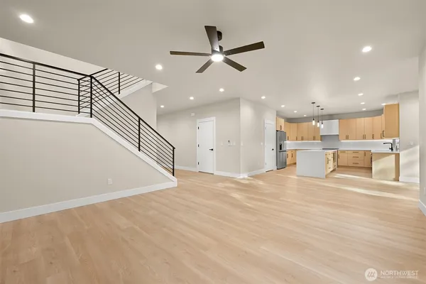 a large kitchen with a large counter top a sink stainless steel appliances and cabinets