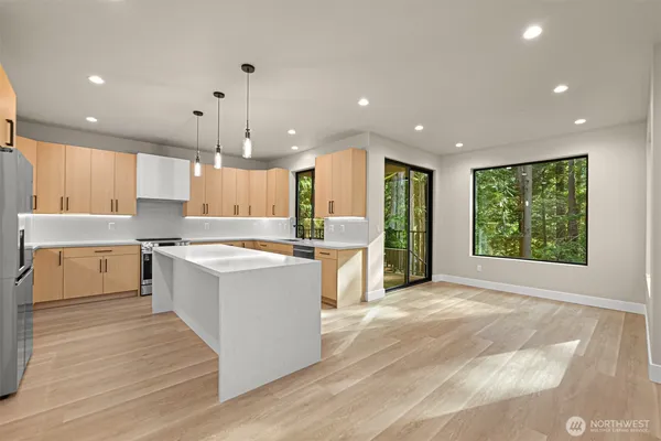 a open kitchen with stainless steel appliances granite countertop a sink a stove and a refrigerator