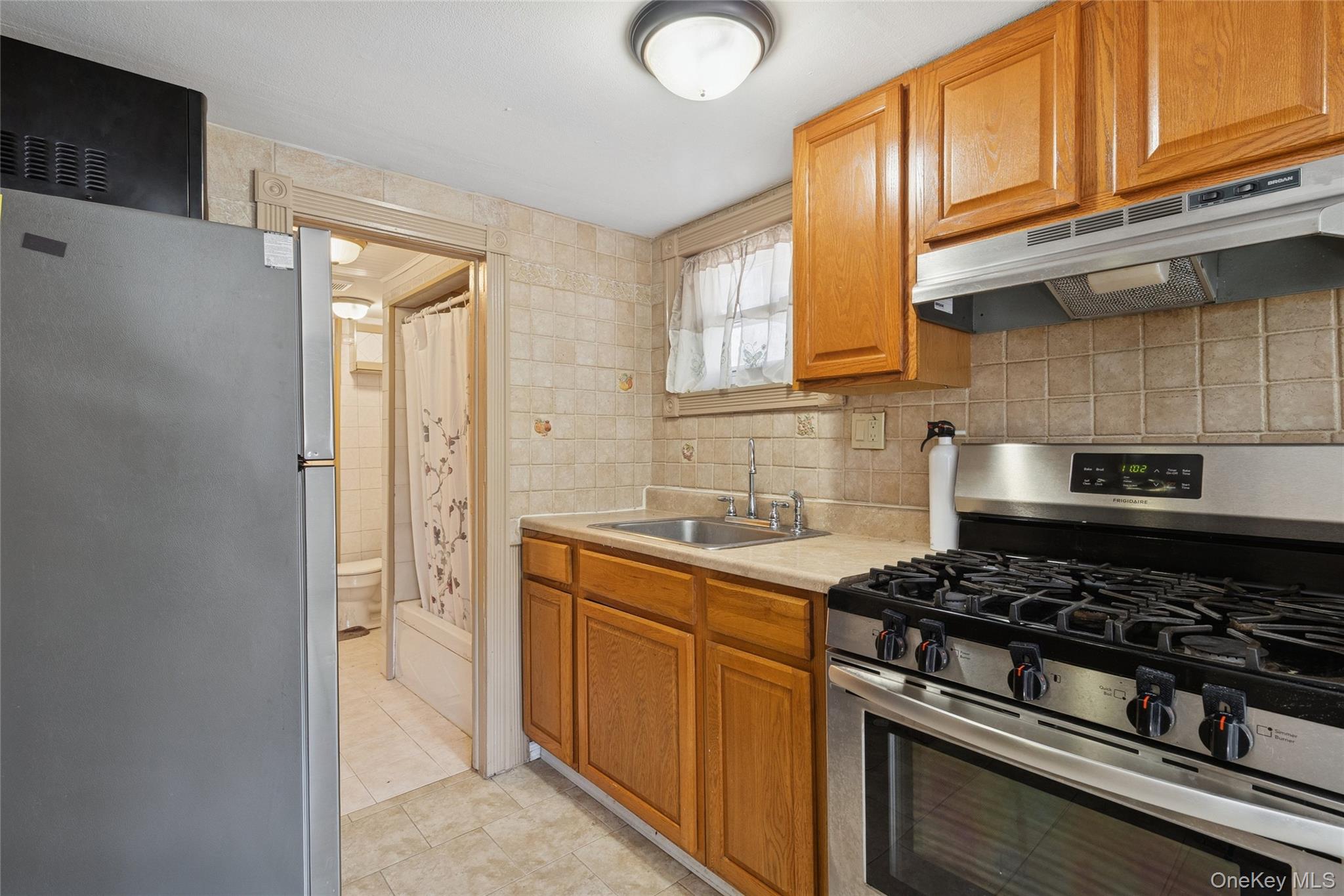 7 Yucca Road Rocky Point, NY 11778 - Photo 16 of 22 a kitchen with stainless steel appliances granite countertop a stove a sink and a refrigerator