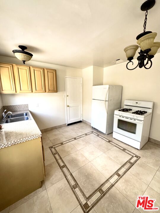 11928 Magnolia Boulevard, Unit 1/4 Valley Village, CA 91607 - Photo 8 of 9 a kitchen with a stove a sink and a refrigerator