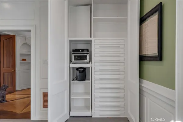 a kitchen with granite countertop a stove a sink and white cabinets