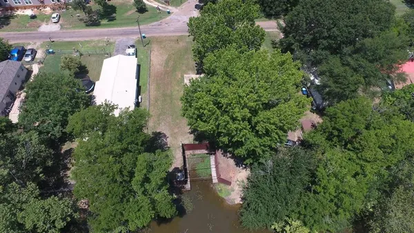 an aerial view of residential house with outdoor space and trees all around