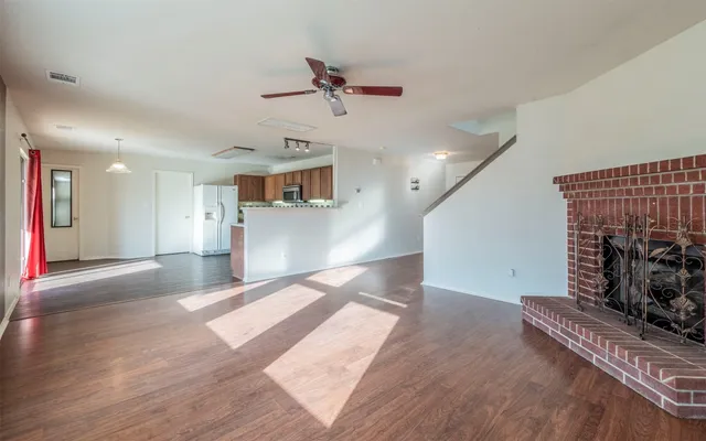 a view of a living room a kitchen and a wooden floor