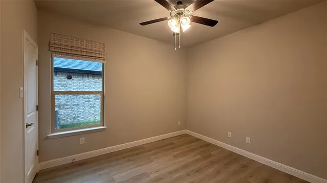 an empty room with a window and wooden floor