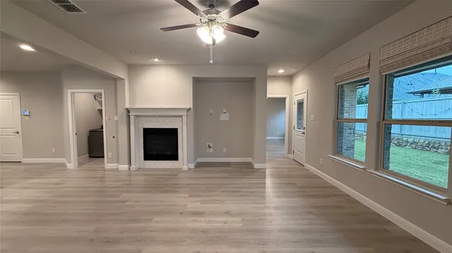 a view of an empty room with a fireplace and a window