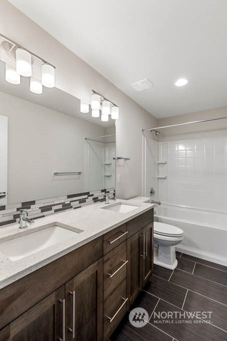 22921 20th Place West Bothell, WA 98021 - Photo 25 of 27 a bathroom with a granite countertop sink toilet a large mirror a bathtub and shower