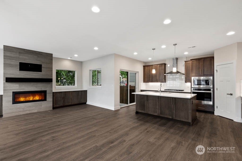 22921 20th Place West Bothell, WA 98021 - Photo 10 of 27 a large kitchen with a large counter top stainless steel appliances and wooden floor