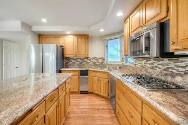 a kitchen with stainless steel appliances granite countertop wooden cabinets a sink and dishwasher