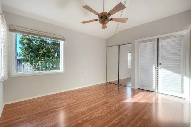 an empty room with windows and fireplace