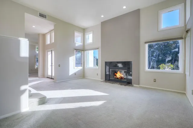 a view of an empty room with a fireplace and a window
