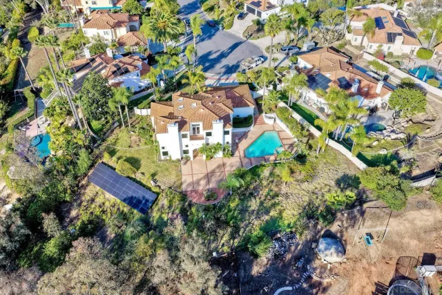 an aerial view of residential houses with outdoor space and trees