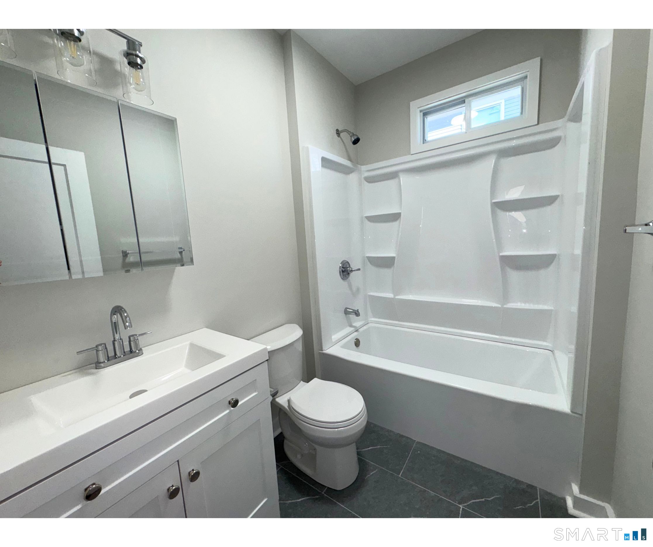 74 Garfield Avenue Bridgeport, CT 06606 - Photo 11 of 14 a bathroom with a sink a toilet a mirror and shower