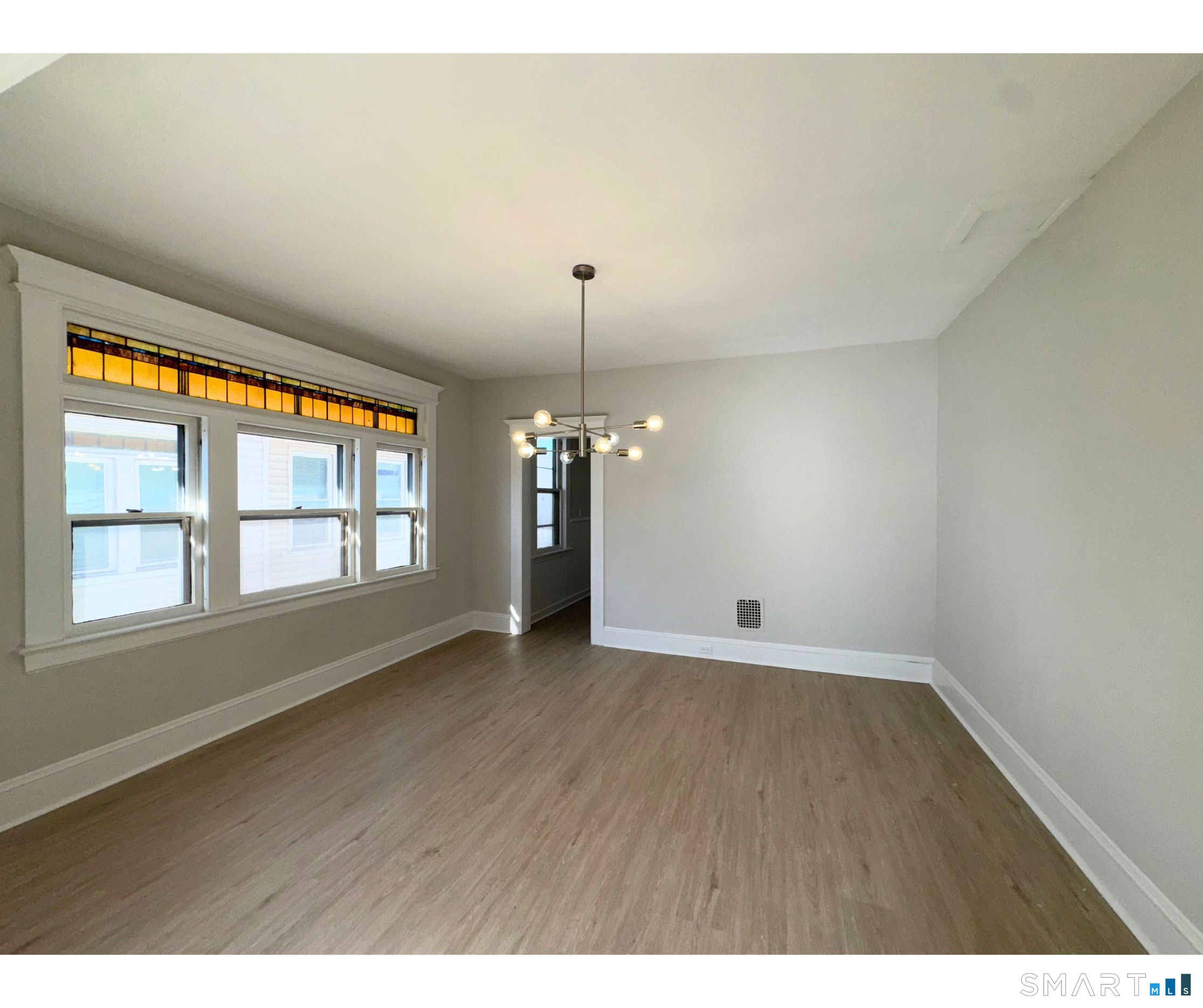 74 Garfield Avenue Bridgeport, CT 06606 - Photo 3 of 14 an empty room with wooden floor and windows