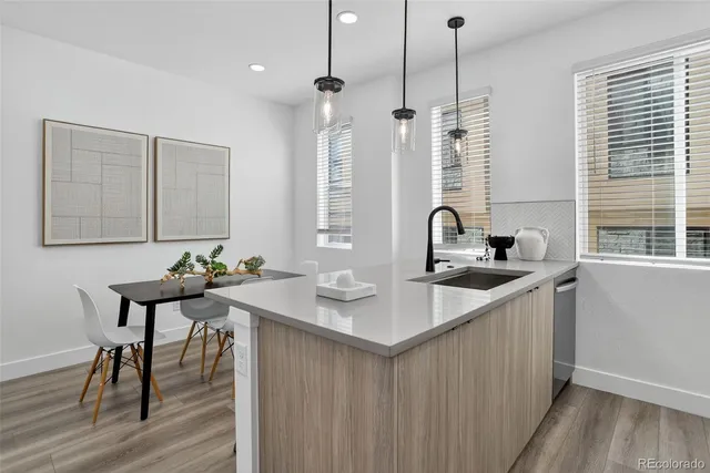 a kitchen with stainless steel appliances a sink dishwasher a refrigerator and cabinets with wooden floor