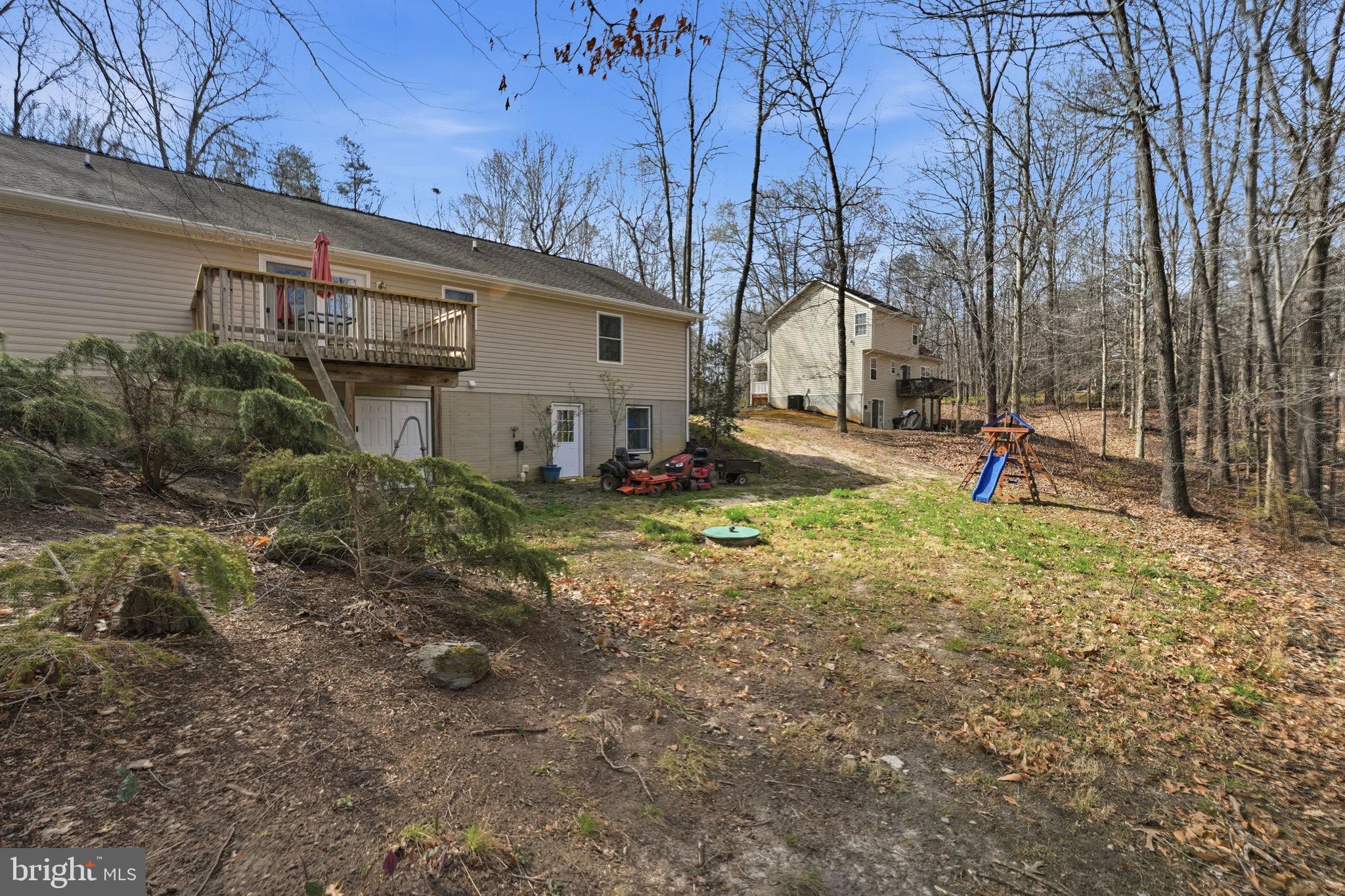 9334 Inaugural Drive King George, VA 22485 - Photo 23 of 26 a backyard of apartments with large trees and plants